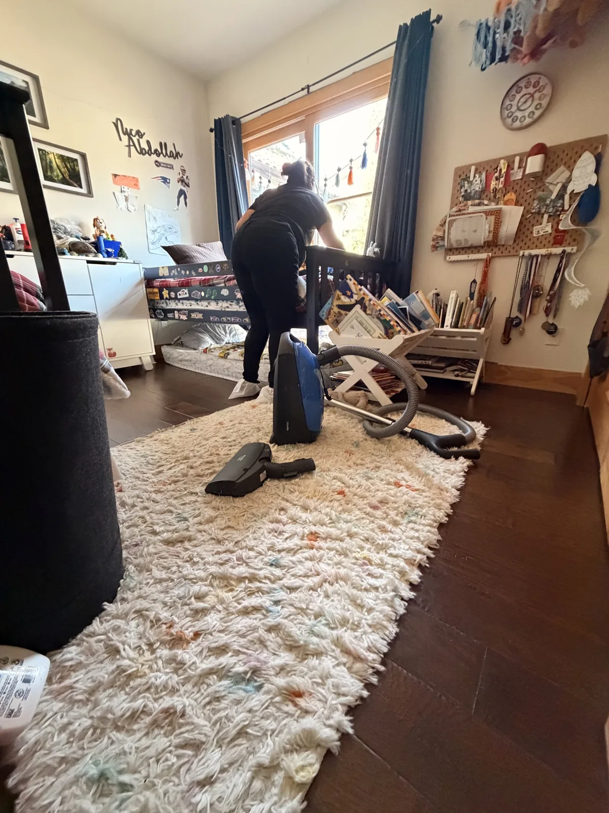 Cleaning team member vacuuming a bedroom